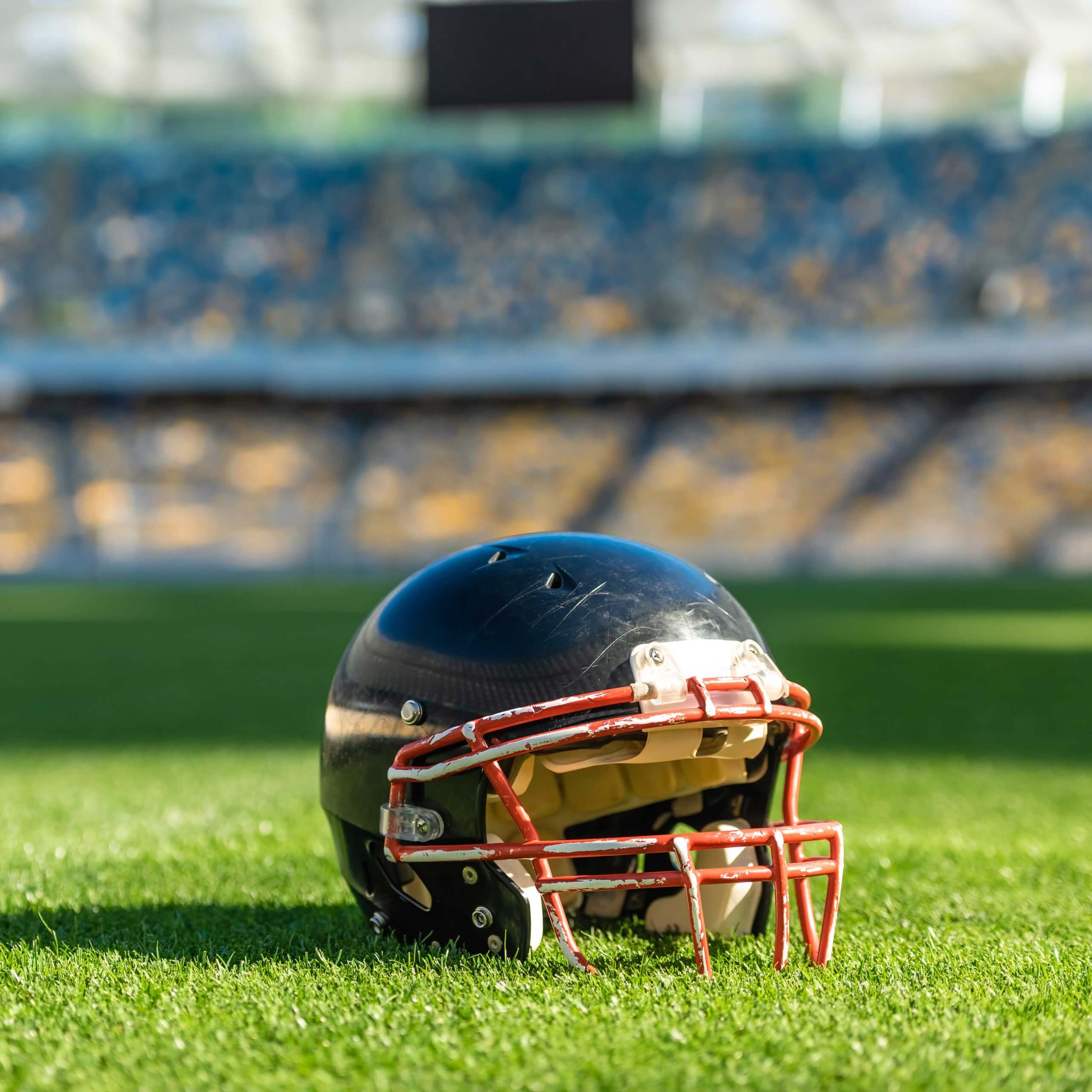 An image of an American football helmet on a field. A visual metaphor for the topic of this newsletter item, climate change and stadium development.